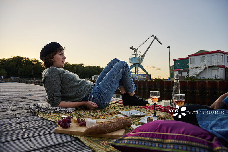 两个成年女人在户外一起分享葡萄酒和面包图片素材