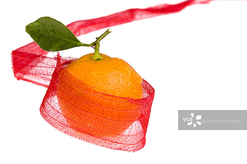 系着红色蝴蝶结的圣诞糖果和橙子图片素材