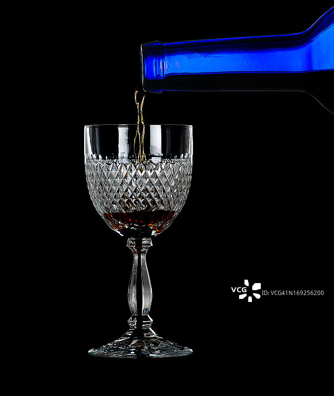 雪利酒或波特酒倒入玻璃杯中图片素材