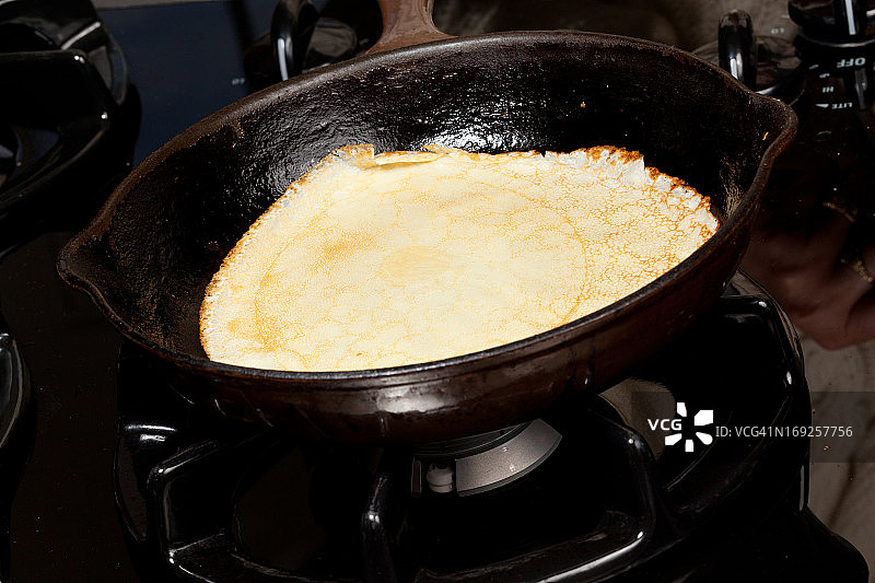 将煎饼混合物倒入煎锅图片素材