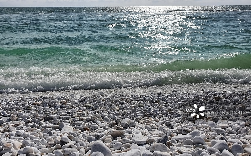 海浪泡沫冲刷着白色鹅卵石图片素材