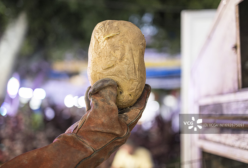 戴皮手套的人手拿着大烤土豆图片素材