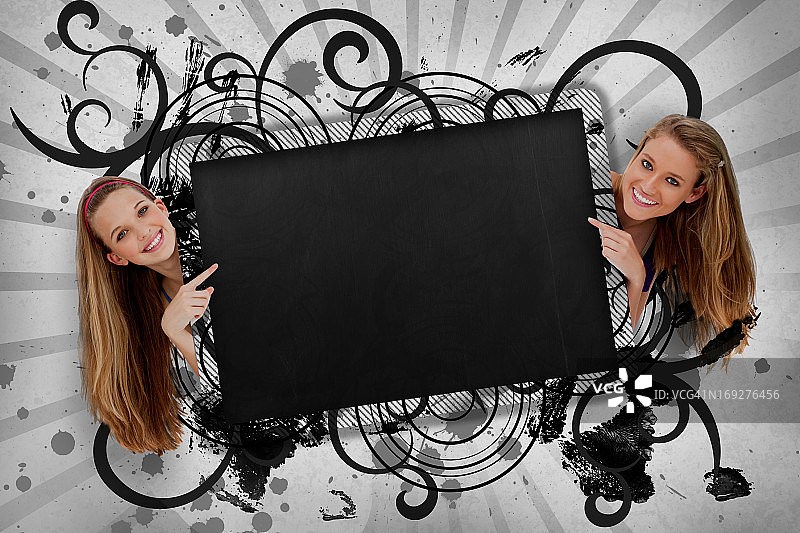 指向带有艺术漩涡框架的黑色复制空间的女孩们图片素材