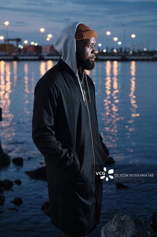 夜晚，独自站在运河边的非裔美国男人图片素材