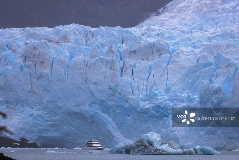 冰川前沿的裂缝与蓝色，前景有船只图片素材