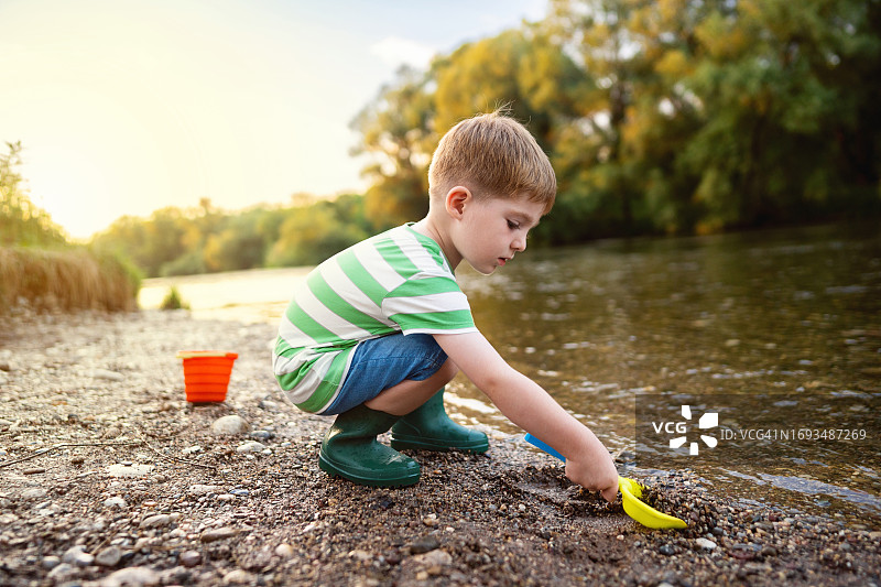 小男孩在河边享受无忧夏日图片素材