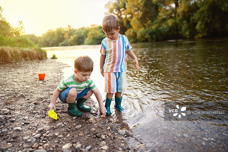 两个小男孩在河边享受无忧无虑的夏日时光图片素材