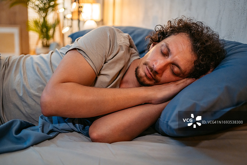 夜晚在床上睡觉的年轻人图片素材