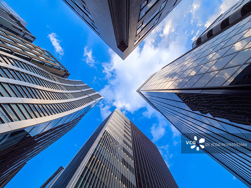 仰望摩天大楼，天空被切割成X形图片素材