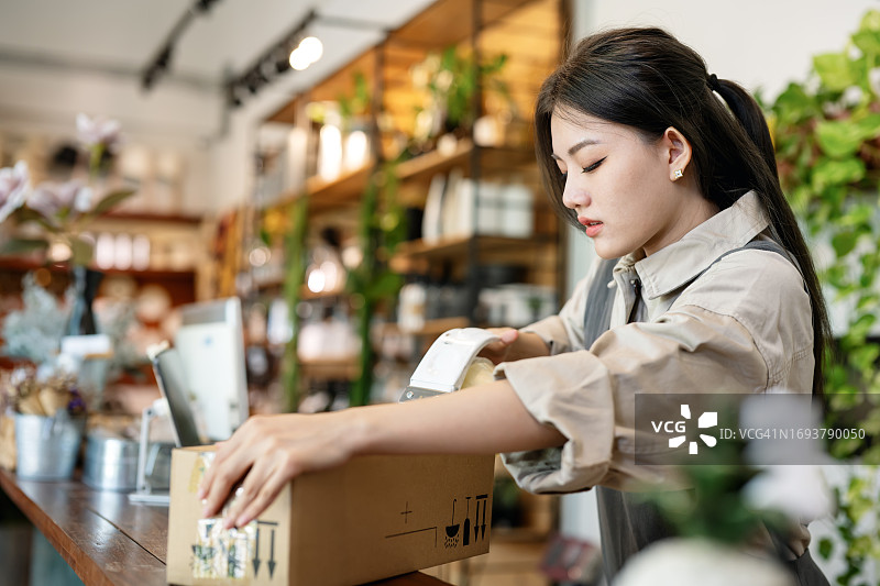 中国花店店主使用手持封箱器打包鲜花图片素材