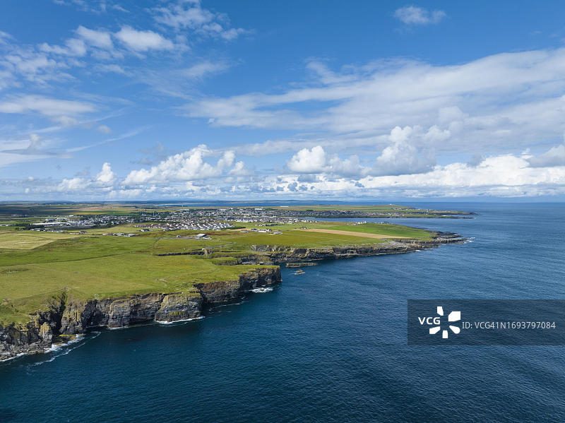 英国苏格兰凯斯内斯郡北海海岸崎岖悬崖的航拍景色，地平线上是威克港镇图片素材