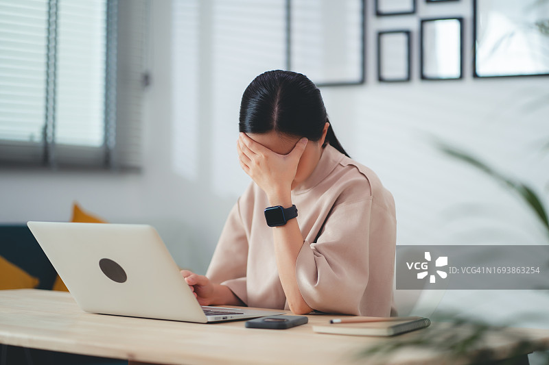 在家中办公室头痛的亚洲女人图片素材