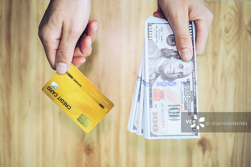 手持信用卡和美元图片素材