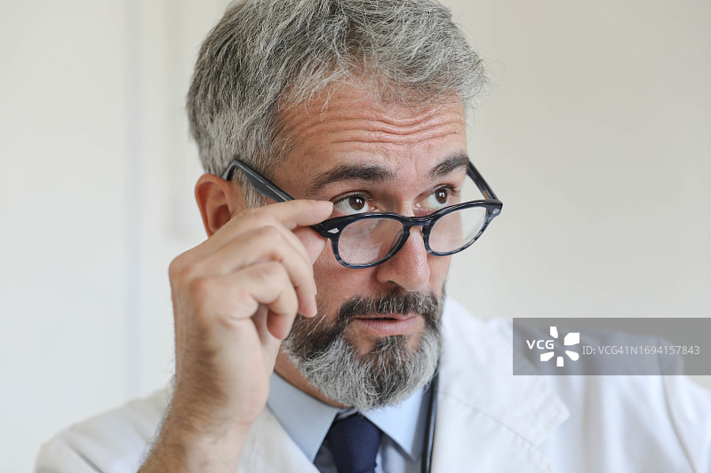 手持眼镜的严肃医生图片素材