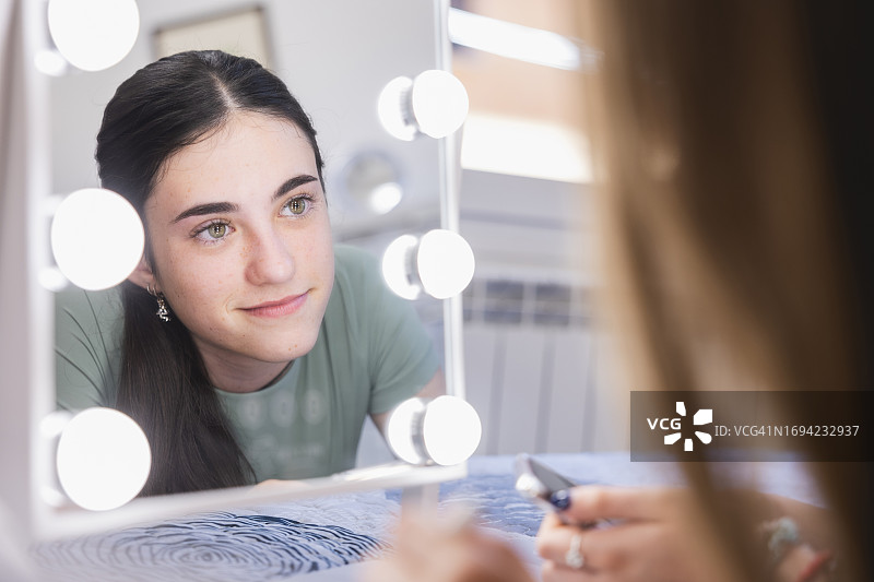 可爱的青少年在家中化妆图片素材