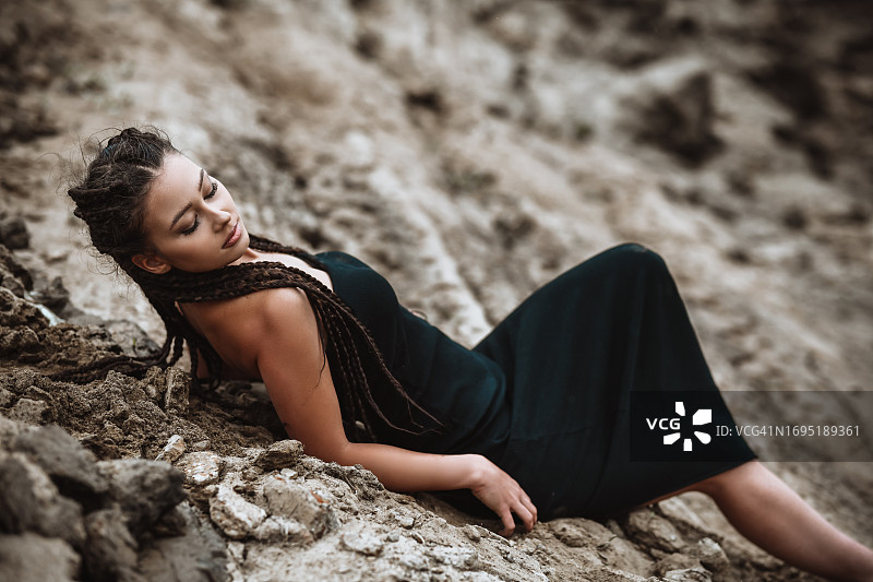 闭着眼睛躺在室外湿沙上的女人图片素材