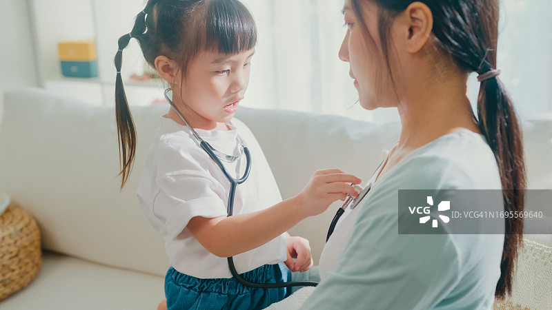亚洲母女在家中客厅玩医生游戏图片素材