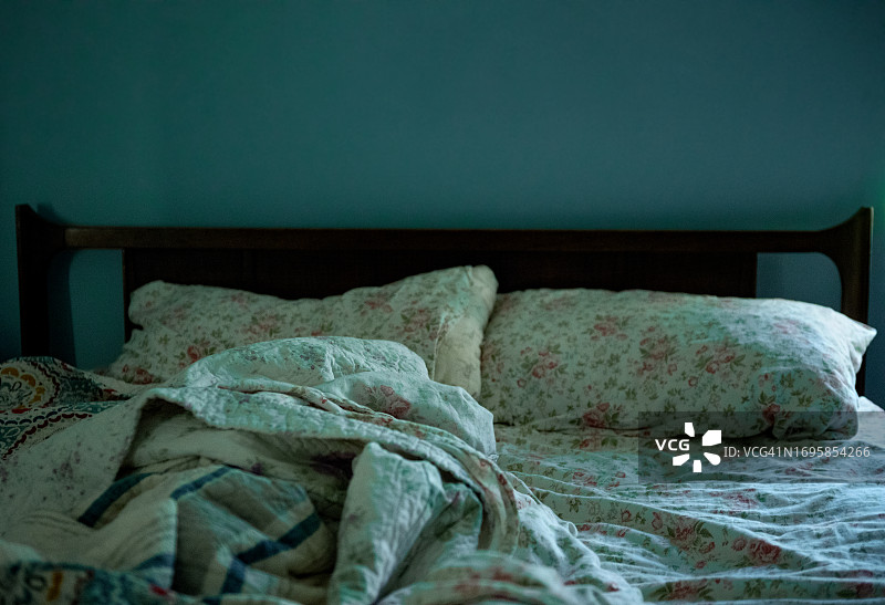 蓝色房间里未整理的床铺图片素材