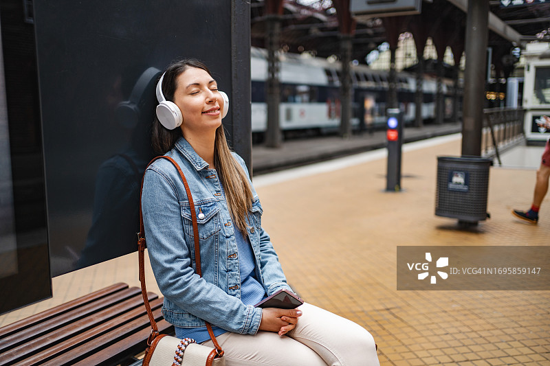 年轻女人在火车站使用手机图片素材
