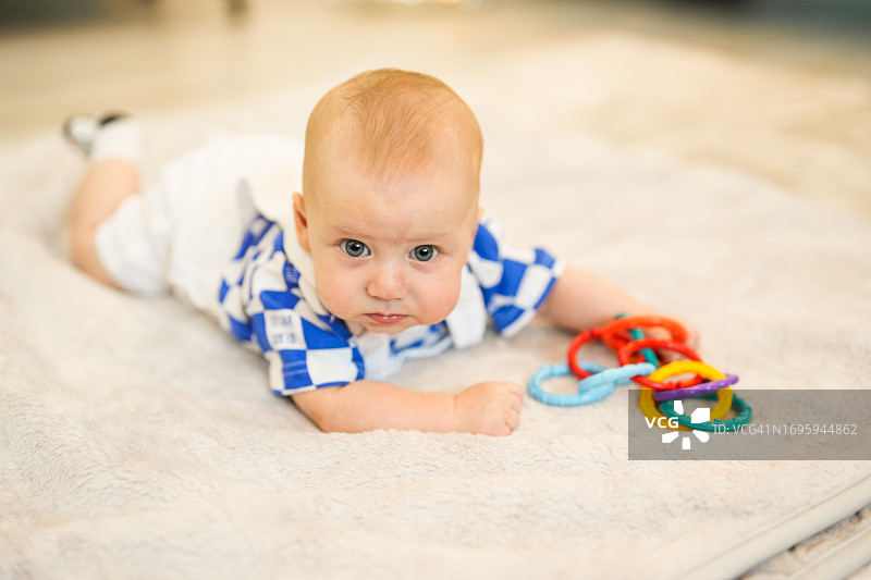6个月大的宝宝在客厅的地板上玩耍图片素材
