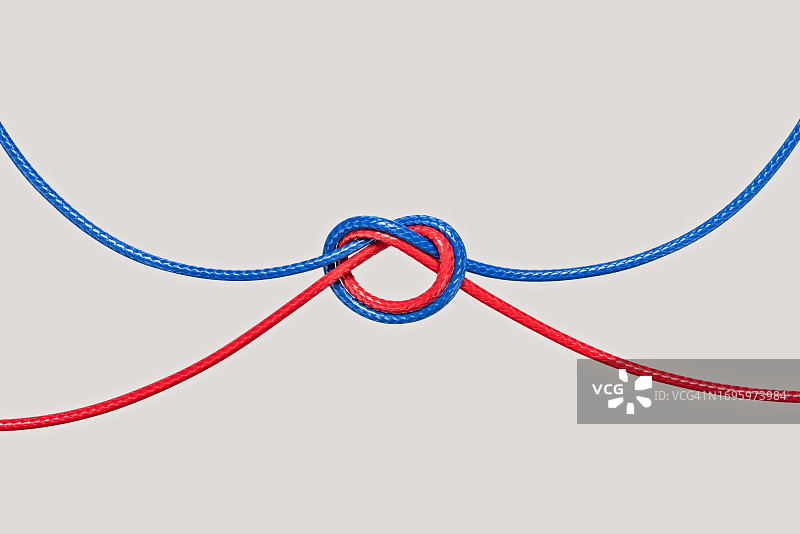米色背景上的蓝红色绳结图片素材