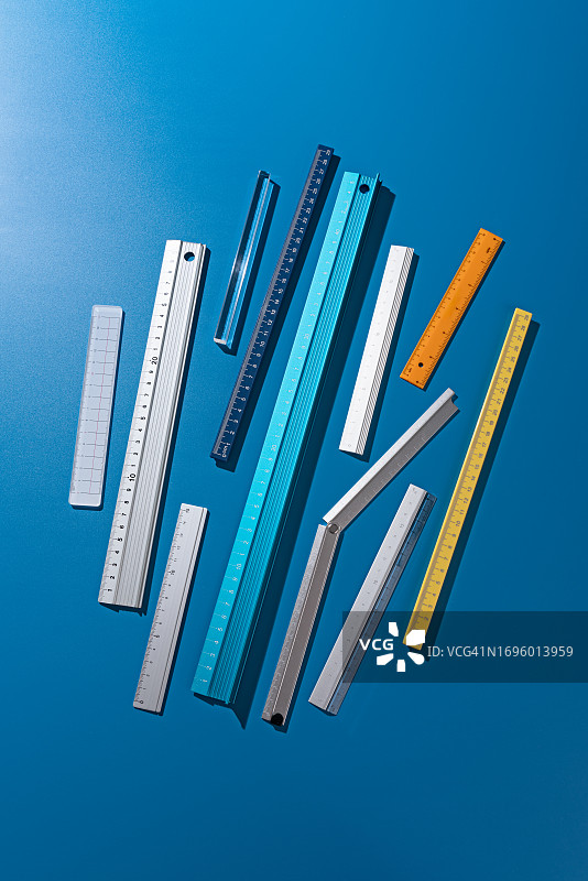 蓝色背景上排列的各种尺子图片素材