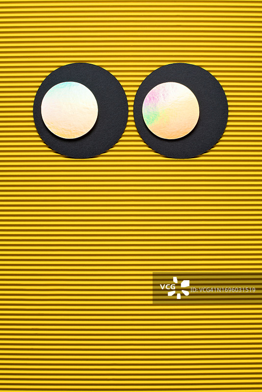 黄色瓦楞纸上的发光全息大眼睛图片素材