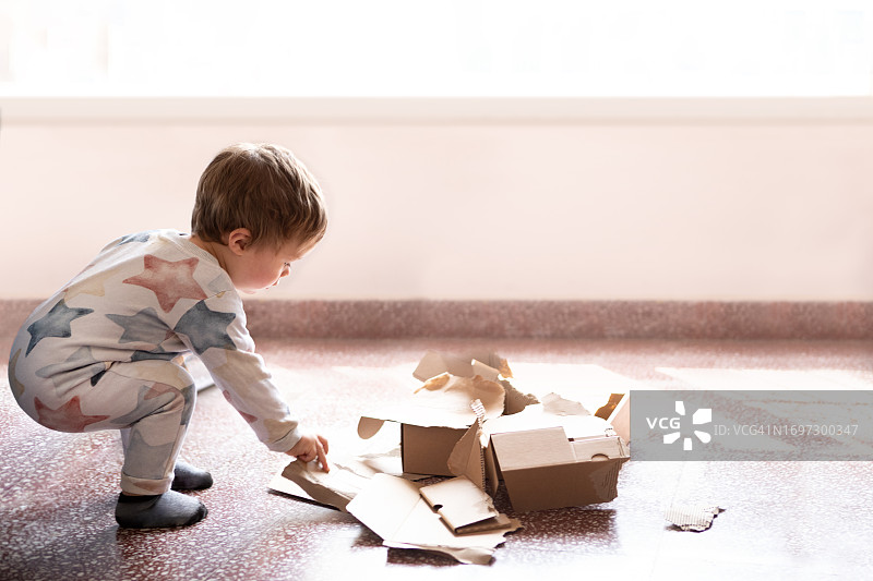 12个月大的宝宝玩破纸箱图片素材