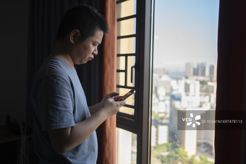 在高楼用手机在玻璃橱窗购物的男人图片素材