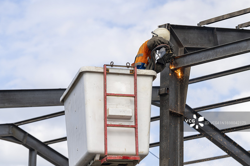 建筑工人在高空车切割钢架图片素材