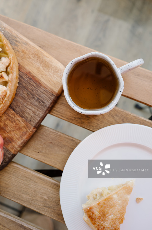 木桌上放着一杯红茶和一块苹果派图片素材