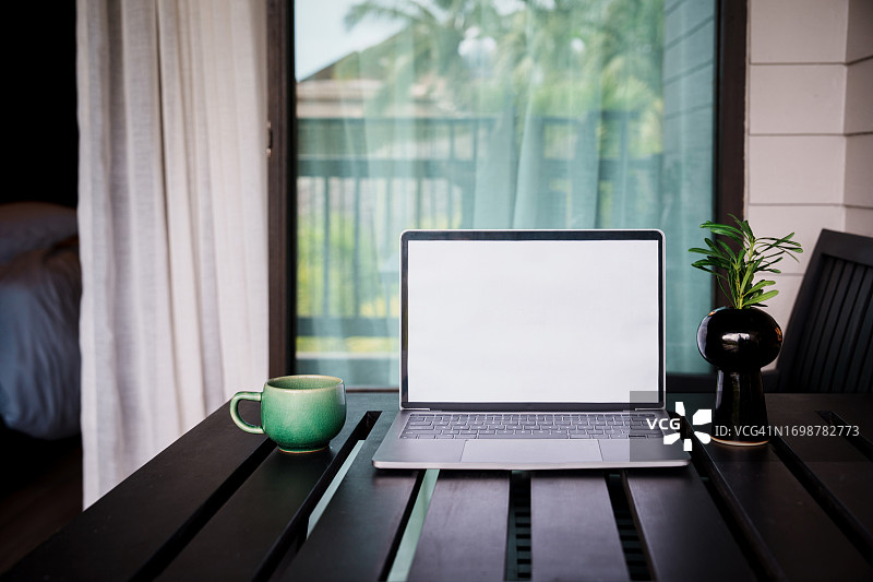 咖啡馆背景中桌子上的笔记本电脑空白屏幕图片素材