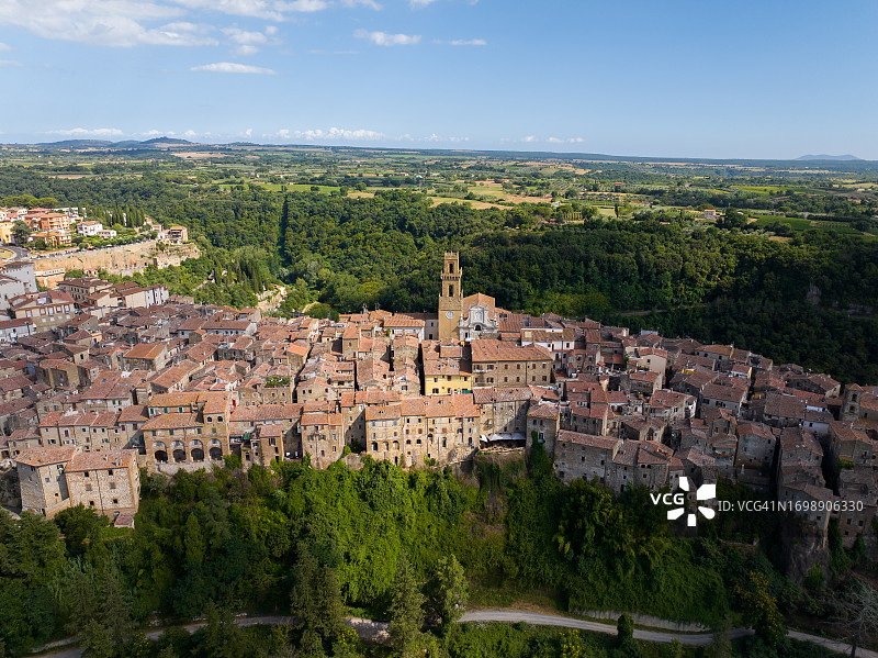 意大利托斯卡纳地区皮蒂利亚诺圣彼得和保罗大教堂的中世纪钟楼，晴朗夏日的航拍景色图片素材