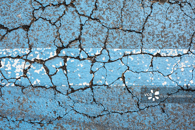 开裂沥青上的彩色条纹图片素材