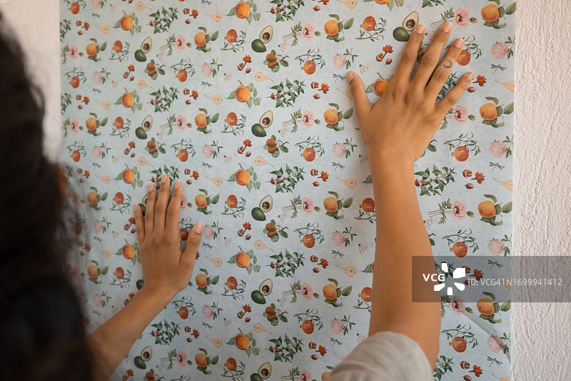 熟练的拉丁裔女设计师正在贴壁纸图片素材