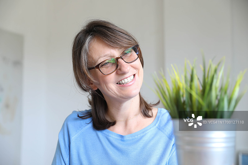 中年妇女在房间里拿着盆栽图片素材