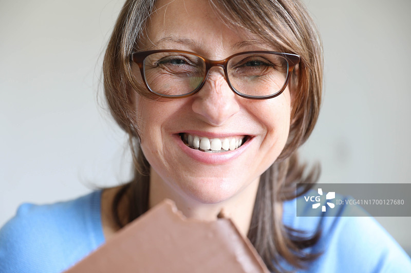 快乐的中年女士吃巧克力图片素材