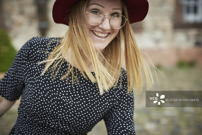 戴帽子和眼镜的快乐女性肖像图片素材