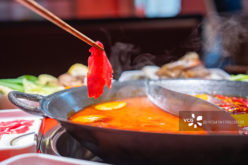 桌子上是在餐厅里吃的鸳鸯火锅，其中一种是麻辣火锅图片素材