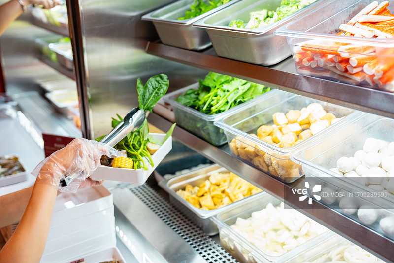 女人从沙拉吧拿新鲜沙拉图片素材