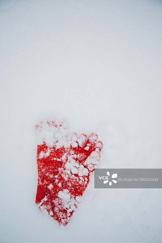 被雪覆盖的红色连指手套图片素材
