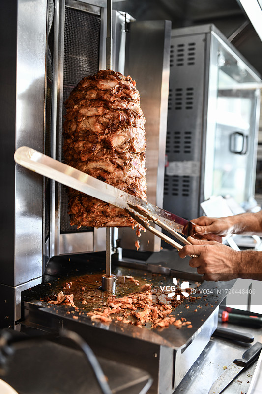 烤肉厨师在烤肉机上切牛肉薄片图片素材