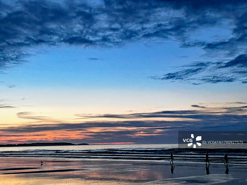 缅因州老果园海滩，日出时分人们行走和海鸥飞翔，海浪拍打图片素材