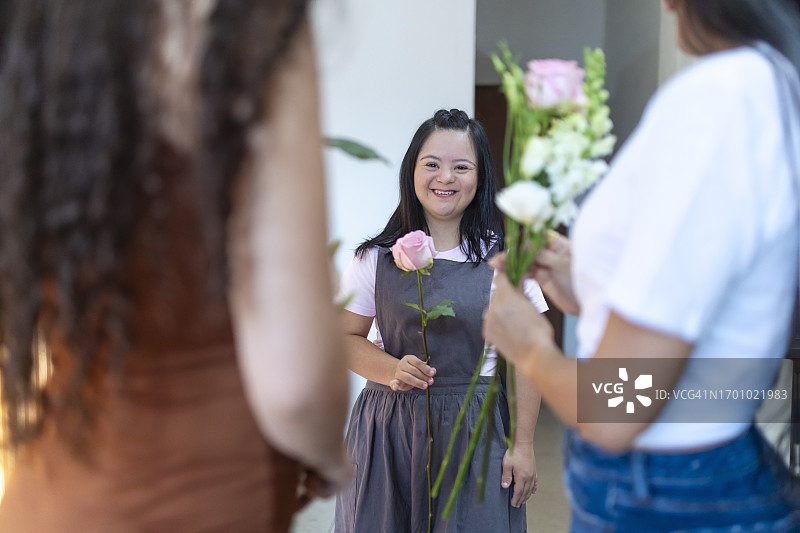 手持玫瑰的残疾年轻女子肖像图片素材