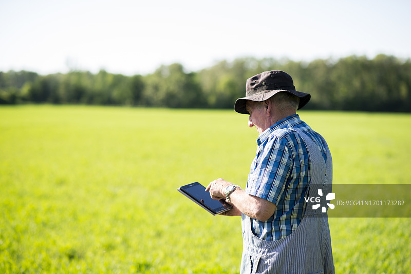 农民使用平板电脑查看农作物图片素材