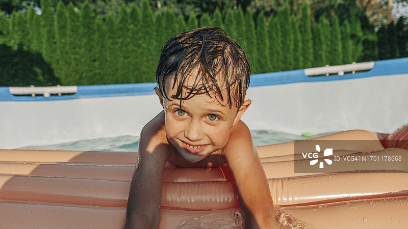 可爱男孩在后院享受夏日游泳乐趣图片素材