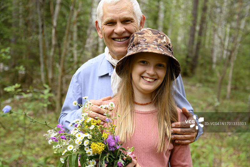 笑容满面的老年男子与孙女在森林里图片素材