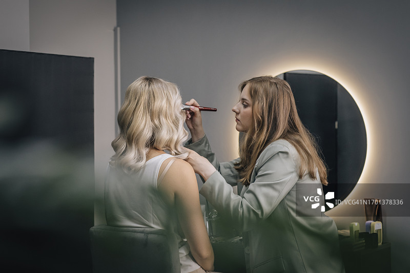 美容师在沙龙为顾客化妆图片素材