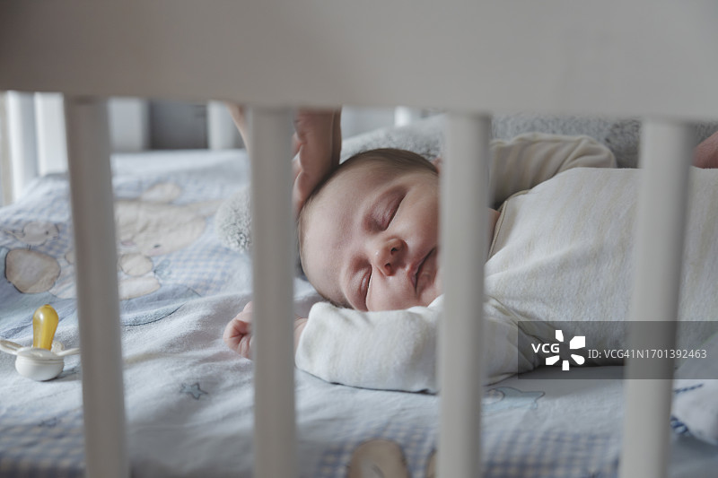 女婴在家中婴儿床里睡觉图片素材