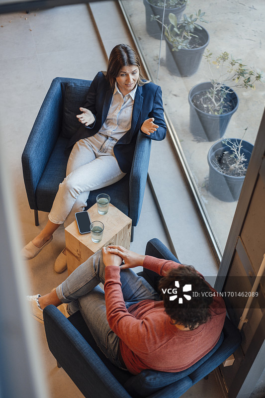 女商人与坐在扶手椅上的男商人进行讨论图片素材